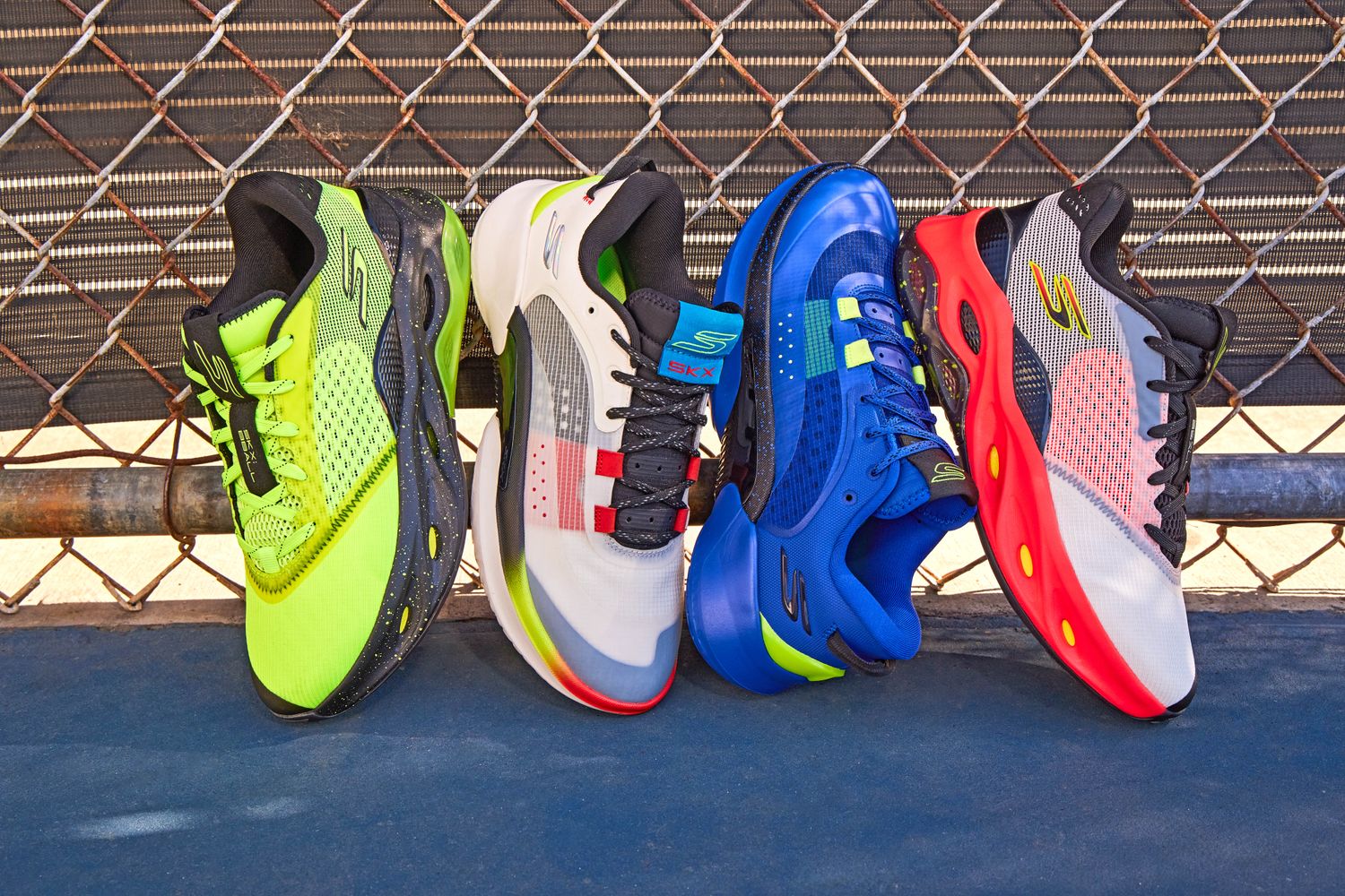 Four multicolor Skechers basketball shoes on an outdoor basketball court.